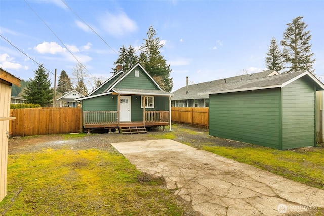 rear view of property with a patio, an outdoor structure, and a fenced backyard