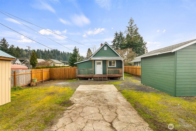 view of front facade featuring an outbuilding, a fenced backyard, and a chimney