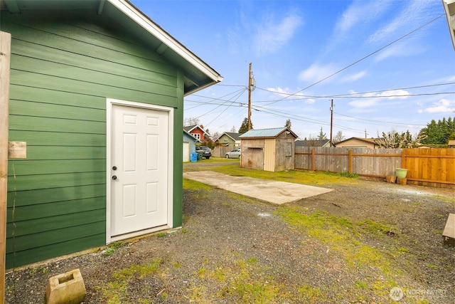 view of yard with a storage unit, an outbuilding, and fence