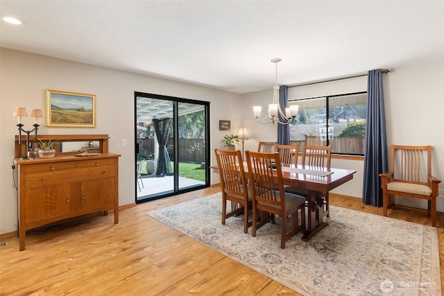 dining space with recessed lighting, baseboards, a notable chandelier, and light wood-style flooring