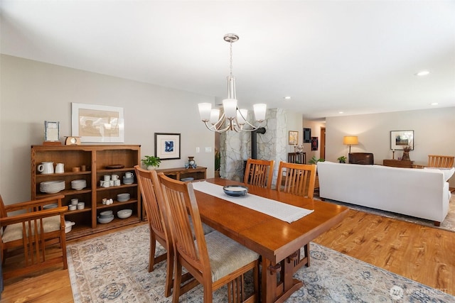 dining space with recessed lighting, wood finished floors, and a chandelier