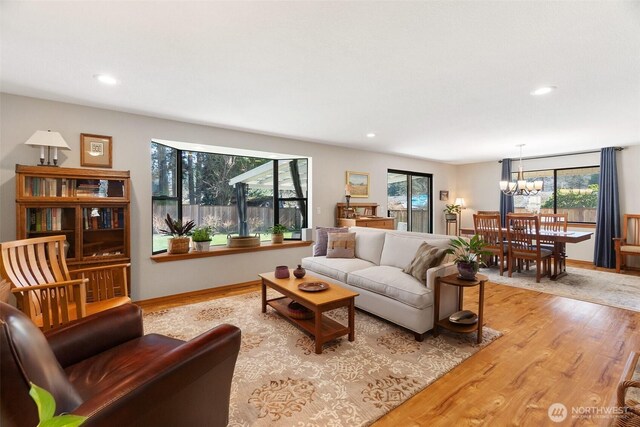 living area featuring recessed lighting, baseboards, an inviting chandelier, and wood finished floors