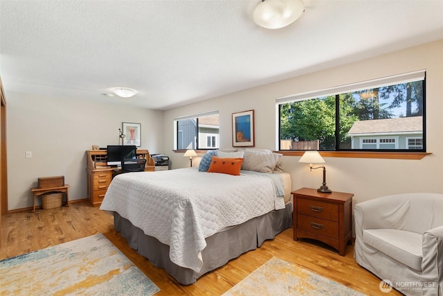 bedroom featuring baseboards and light wood-style floors