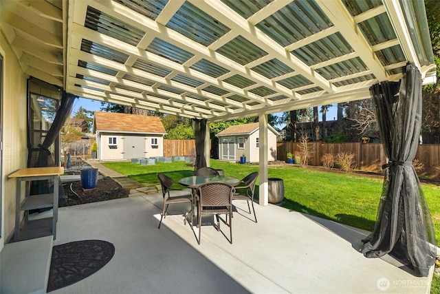 view of patio / terrace featuring outdoor dining space, a storage unit, and an outdoor structure