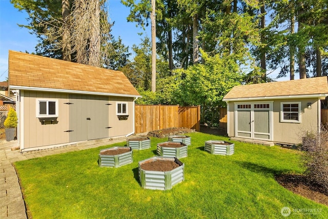 view of yard with an outbuilding, a vegetable garden, fence, and a shed