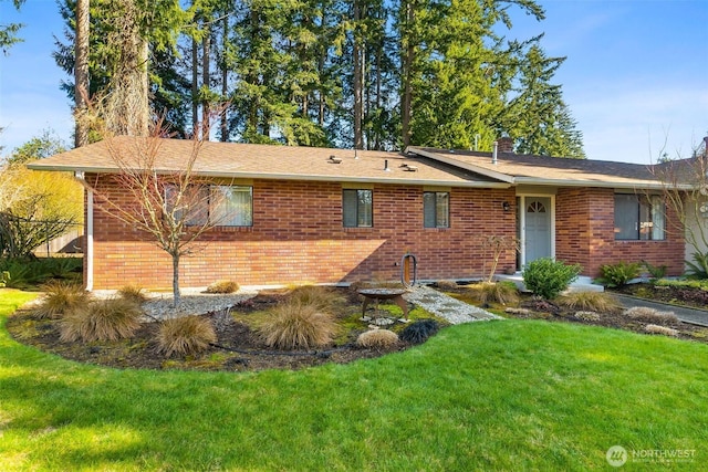 view of front of property featuring brick siding and a front yard