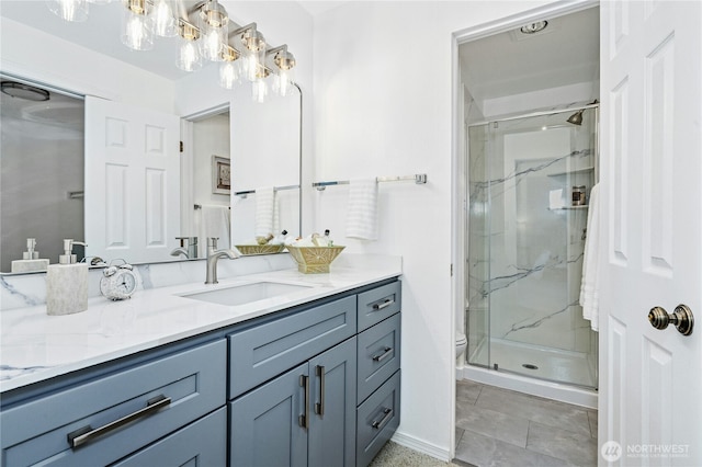 full bath with a marble finish shower, toilet, vanity, and baseboards