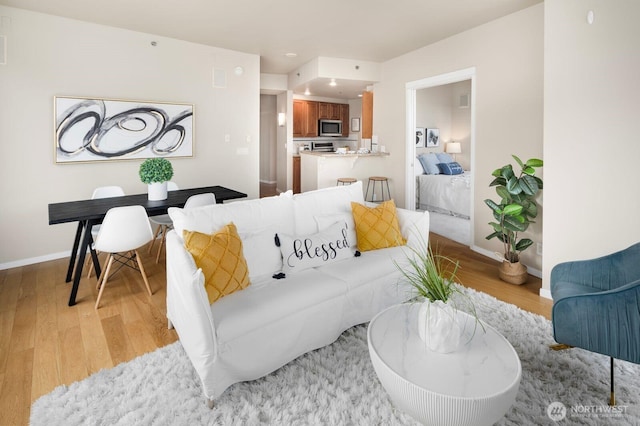 living area with light wood finished floors and baseboards