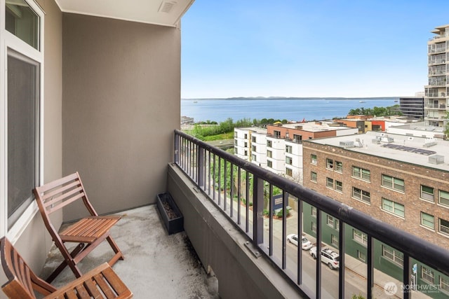 balcony featuring visible vents and a water view