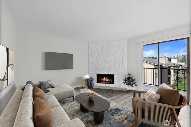 living room featuring baseboards, wood finished floors, and a high end fireplace