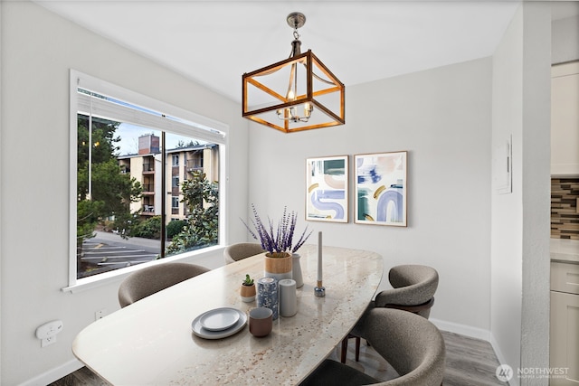 dining area with an inviting chandelier, wood finished floors, and baseboards