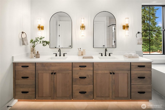 bathroom with a sink, a bath, and double vanity