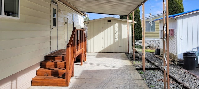 view of patio with an outbuilding, a storage unit, and fence