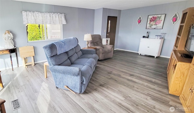 living area with baseboards and wood finished floors