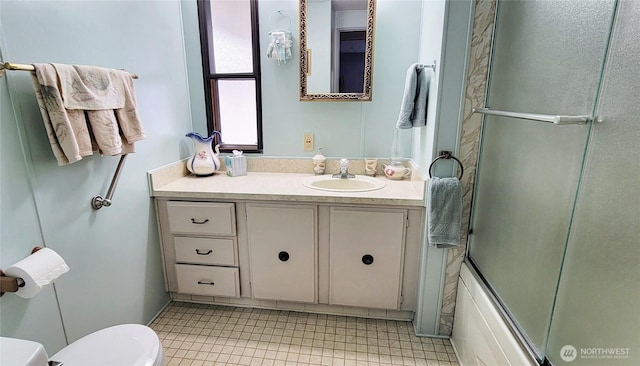 bathroom with vanity, toilet, and enclosed tub / shower combo