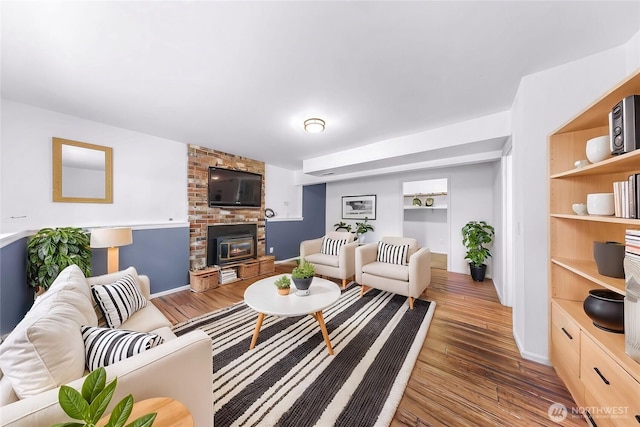 living area with built in shelves and wood finished floors