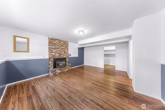 unfurnished living room with a fireplace, baseboards, and hardwood / wood-style floors