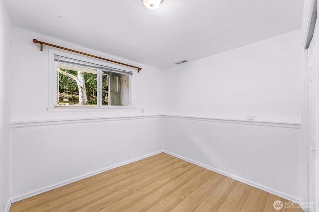 unfurnished room with light wood-style flooring, baseboards, and visible vents