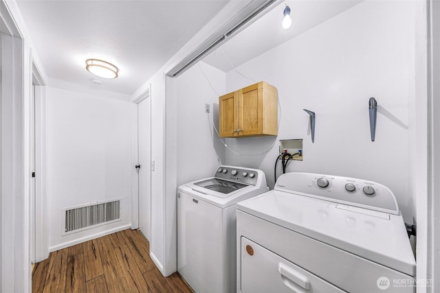 laundry room featuring washing machine and clothes dryer, laundry area, visible vents, and dark wood-style flooring