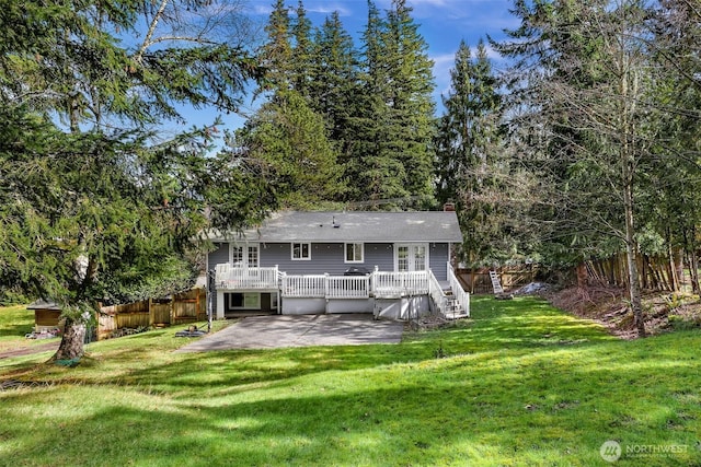 back of property with a deck, a lawn, a patio, and fence