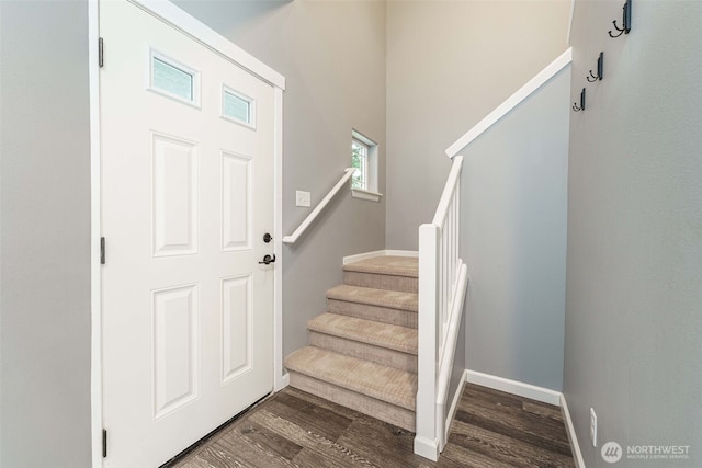 entryway featuring stairway, baseboards, and dark wood-style flooring