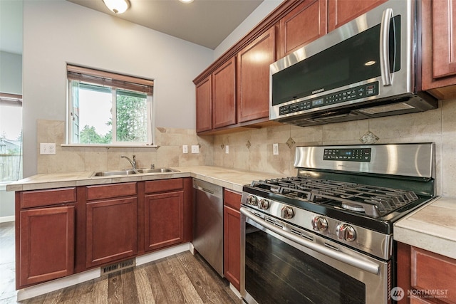 kitchen featuring visible vents, a sink, tasteful backsplash, stainless steel appliances, and light countertops