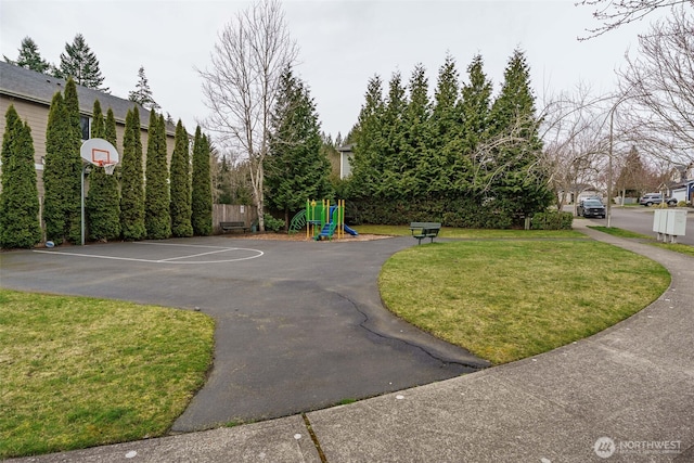 view of basketball court featuring playground community, a lawn, and community basketball court