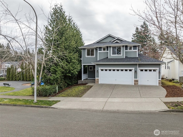 view of front of home featuring a garage, stone siding, driveway, and a shingled roof