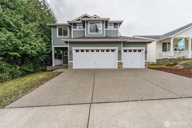 view of front of home with a garage, covered porch, stone siding, and driveway