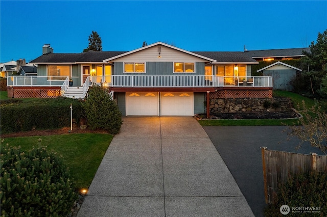 view of front of home with driveway, an attached garage, and a front yard