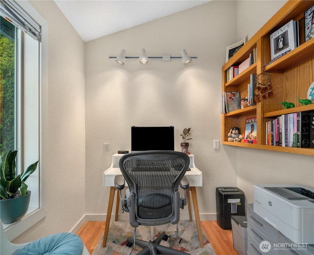 office with light wood finished floors, baseboards, and vaulted ceiling