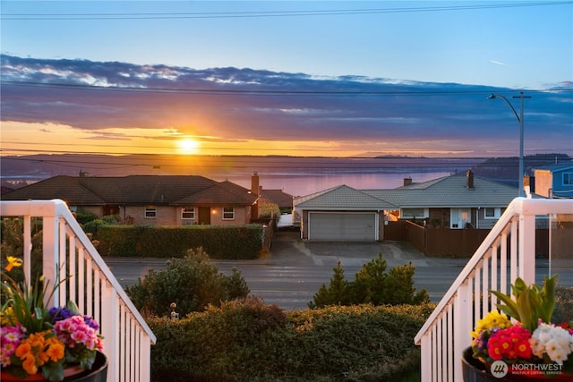 view of front of property featuring a garage, fence, driveway, and a tile roof