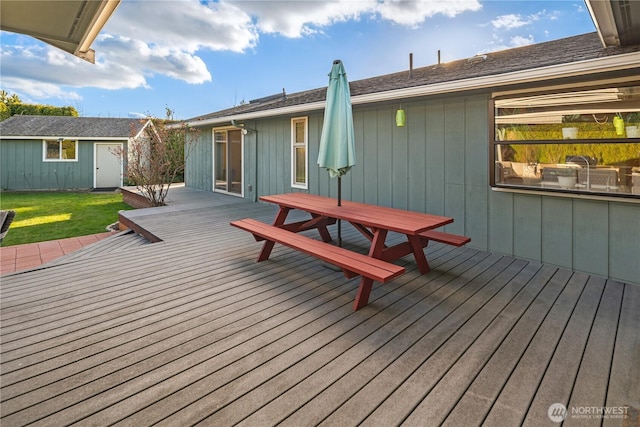 wooden deck with a yard and an outdoor structure