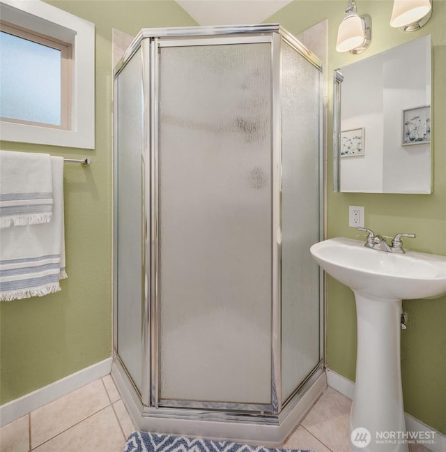 bathroom with tile patterned flooring, a shower stall, and baseboards