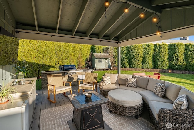 view of patio / terrace featuring a shed, a wooden deck, an outdoor hangout area, an outdoor structure, and a sink