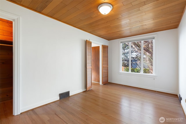 unfurnished bedroom featuring light wood-style flooring, wood ceiling, visible vents, and baseboards