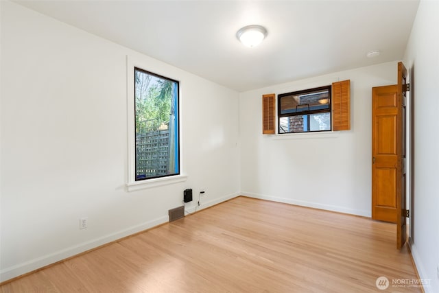 empty room with visible vents, baseboards, and light wood-style flooring