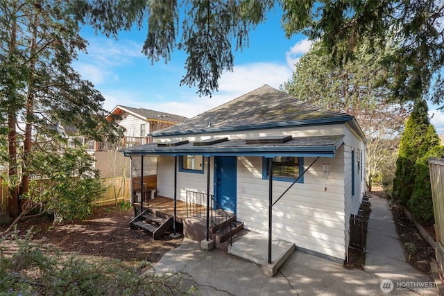 back of property featuring roof with shingles and fence