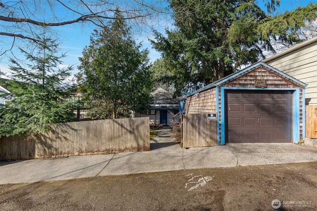 garage featuring driveway and fence