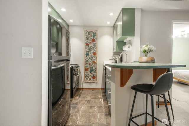 laundry room with recessed lighting and baseboards