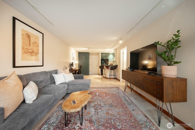 living area featuring track lighting and light tile patterned flooring