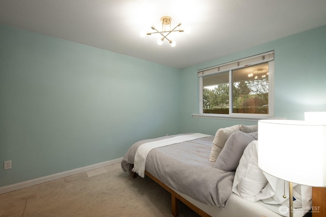 bedroom featuring a notable chandelier and baseboards