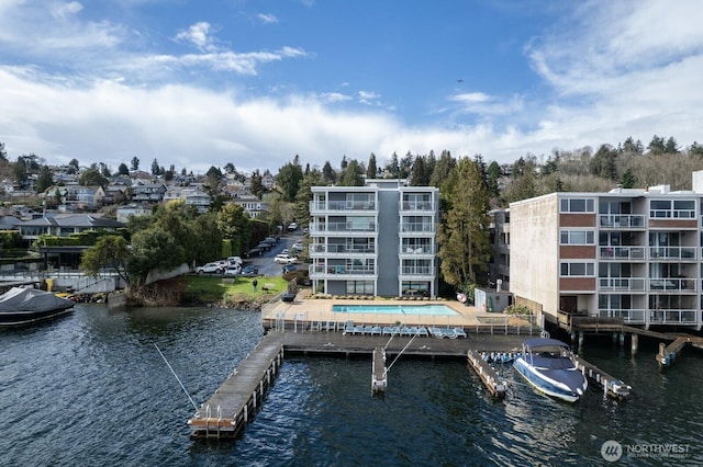 dock area featuring a community pool and a water view