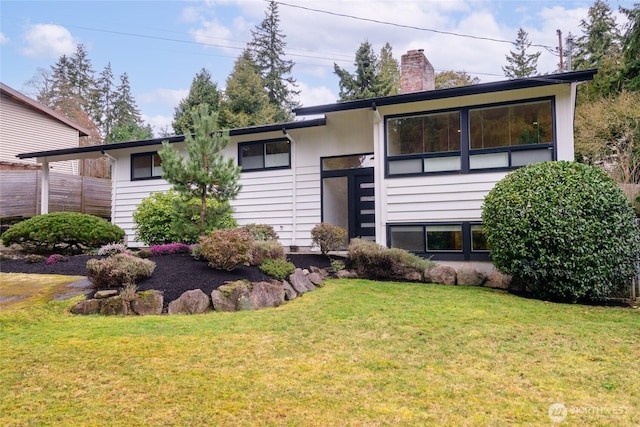 view of front of house with a chimney and a front yard