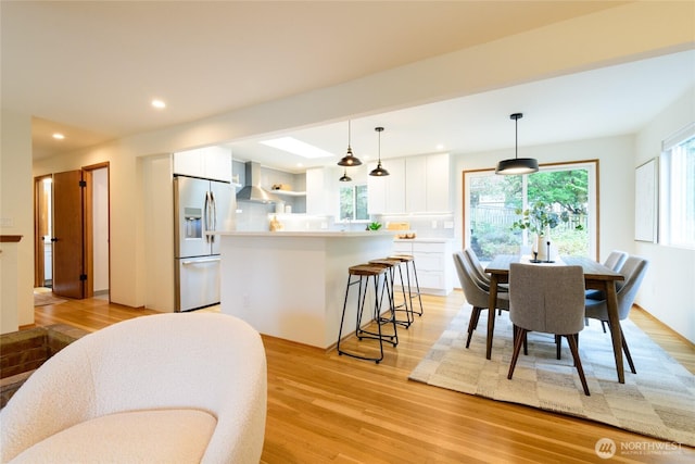 dining room featuring recessed lighting, plenty of natural light, and light wood finished floors