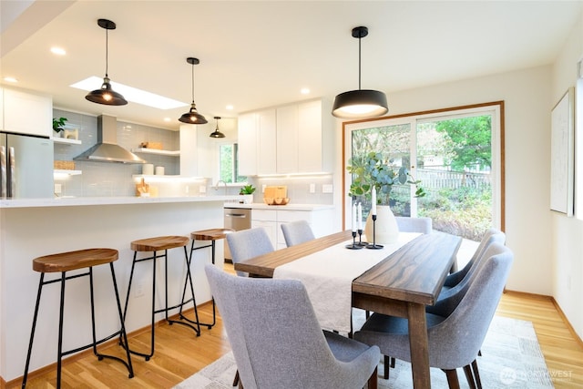 dining space featuring recessed lighting and light wood-style flooring