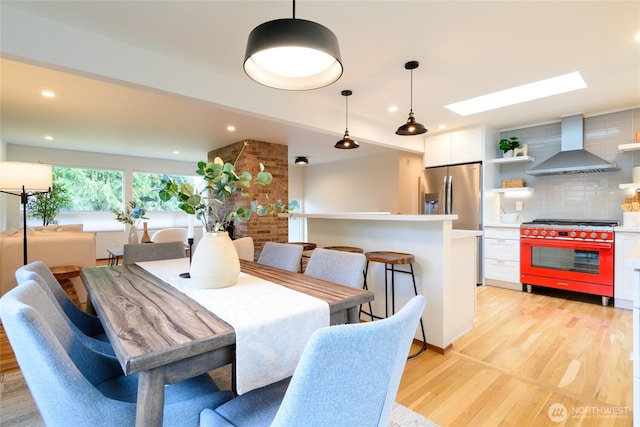 dining area with recessed lighting, light wood-type flooring, and a skylight