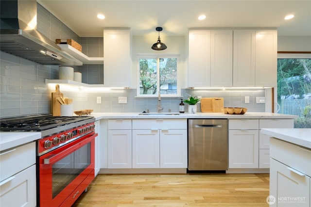 kitchen featuring a sink, appliances with stainless steel finishes, white cabinetry, wall chimney exhaust hood, and open shelves