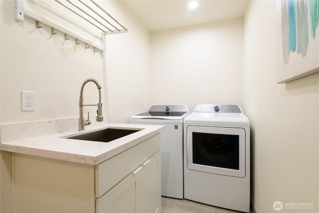 laundry room with light tile patterned floors, independent washer and dryer, cabinet space, and a sink