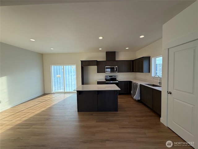 kitchen with a sink, a center island, a healthy amount of sunlight, and stainless steel appliances